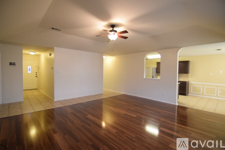 A room with wooden flooring and a ceiling fan.