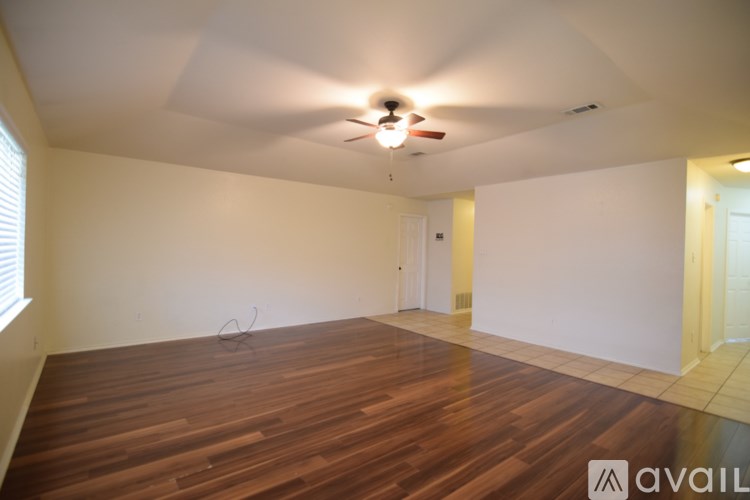 A room with wooden flooring and a ceiling fan.