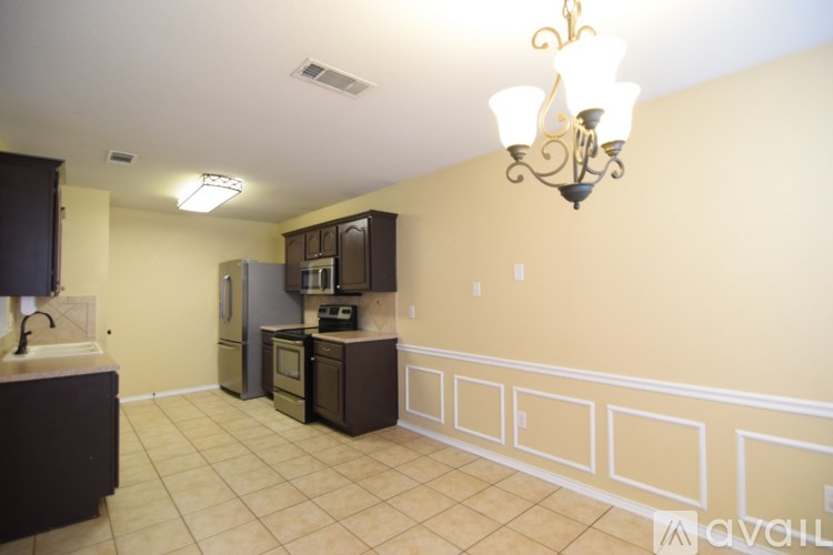 A kitchen with a refrigerator, oven, and sink.