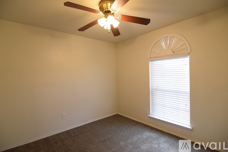 A room with a ceiling fan and a window with blinds.