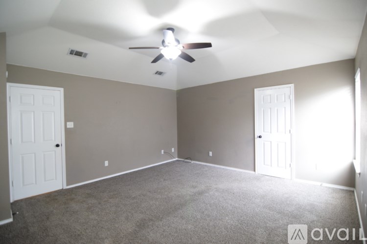 A room with a ceiling fan and two doors.