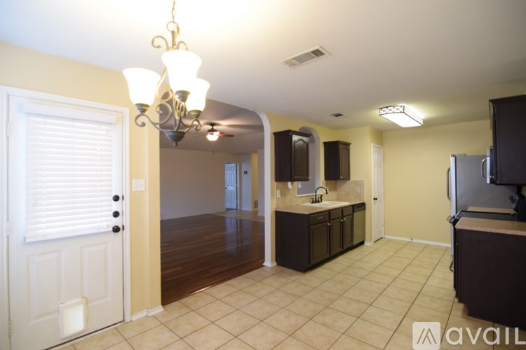A kitchen area with a refrigerator, microwave, and cabinets.