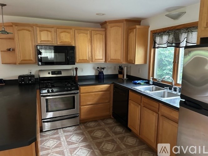 A kitchen with wooden cabinets and black appliances.