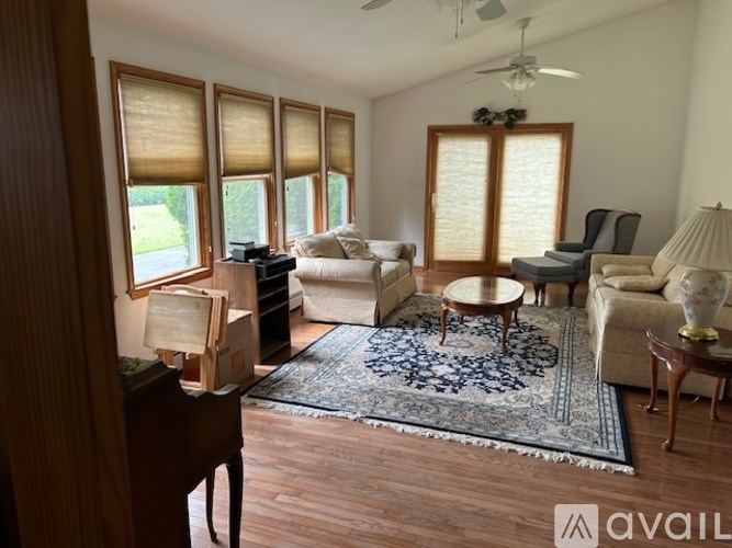 A living room with a piano and a rug.