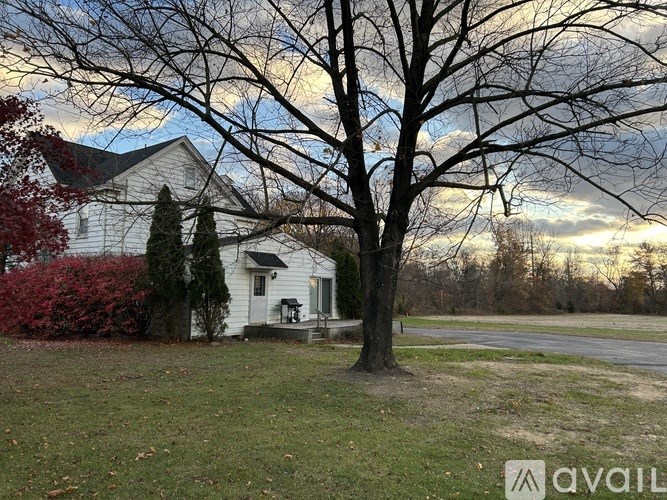 A white house with a tree in front of it.