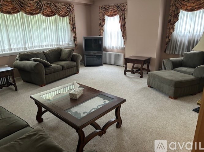 A living room with a television, couches, and a coffee table.