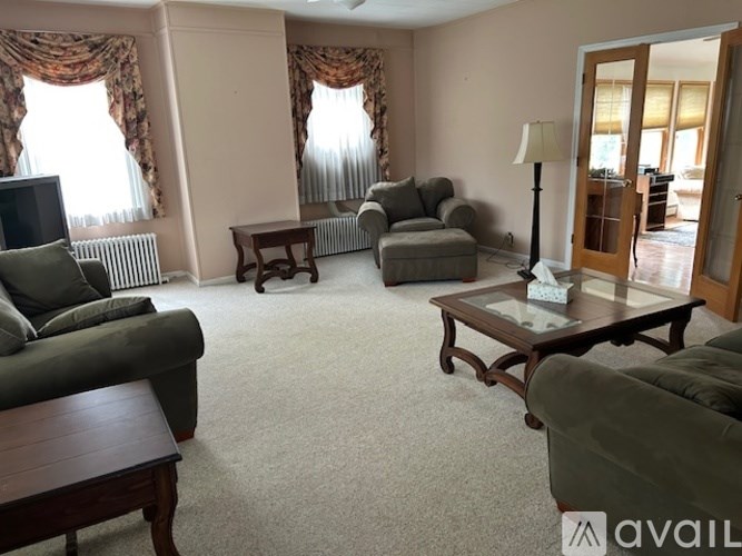 A living room with a grey couch, a wooden coffee table, and a television.
