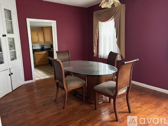A dining room with a glass table and chairs.