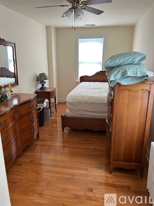 A bedroom with a bed, dresser, and mirror.