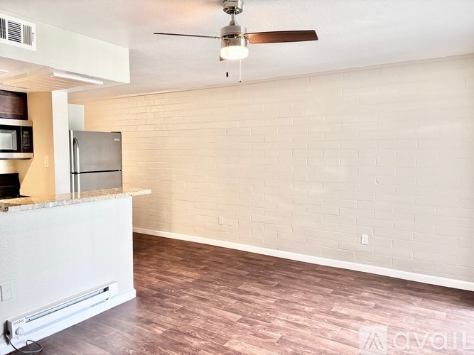 A kitchen with a refrigerator and a ceiling fan.