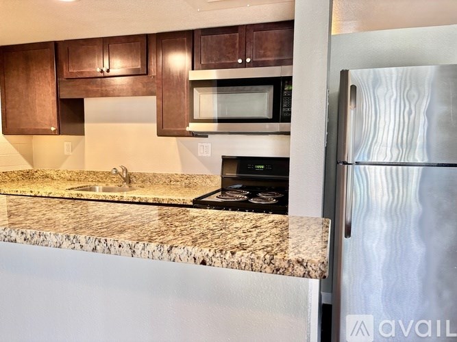 A kitchen with a granite countertop and stainless steel appliances.