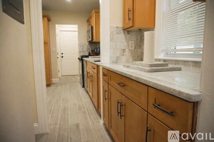 A kitchen with wooden cabinets and a marble countertop.