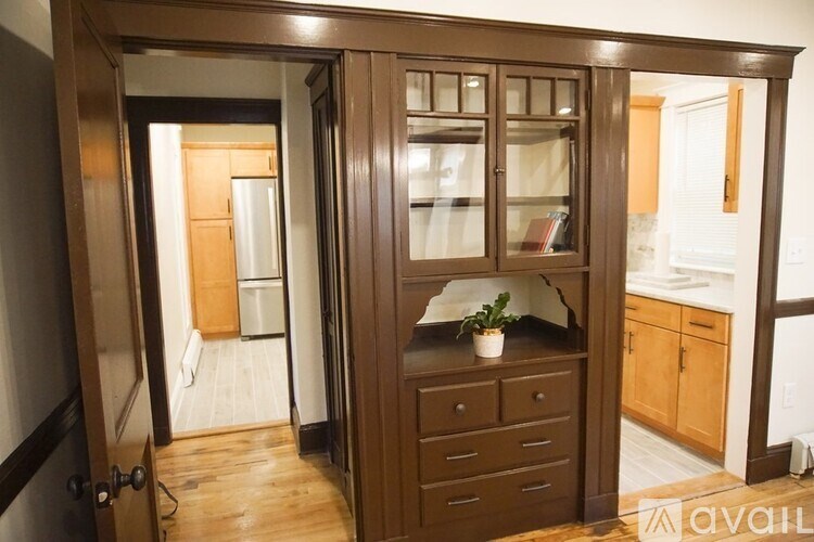 A brown cabinet with glass doors is in the foreground.