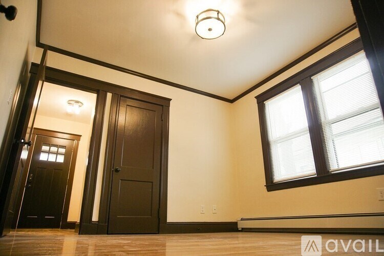A room with a window and a wooden floor.