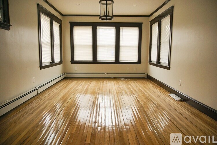 A room with wooden flooring and a chandelier.