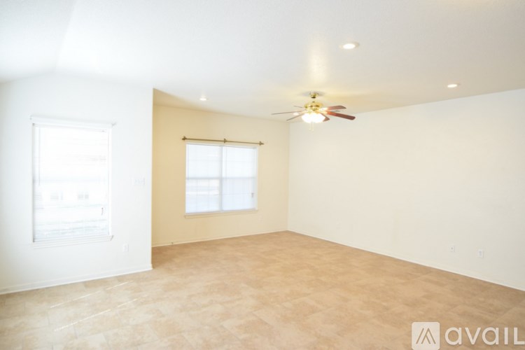 A room with a ceiling fan and a window.