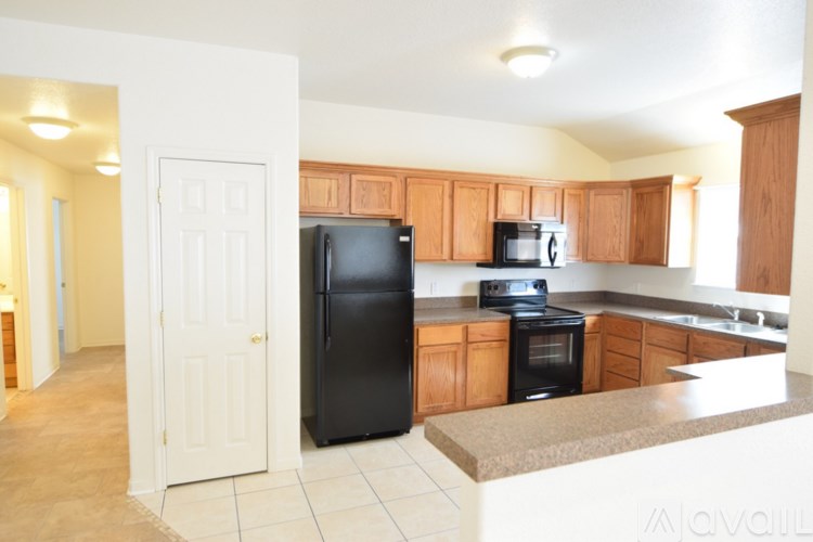 A kitchen with black appliances and wooden cabinets.
