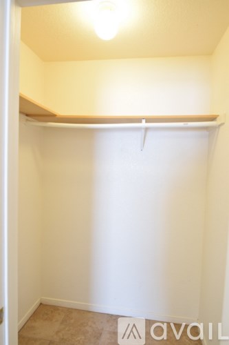 A small white closet with a light on.