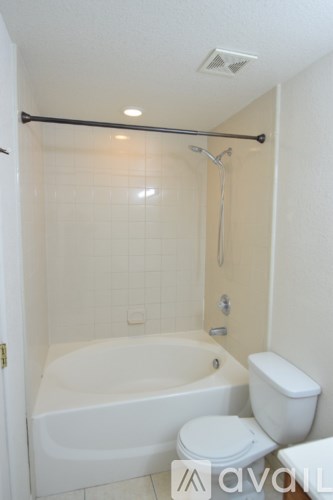 A white bathroom with a toilet, tub and shower.