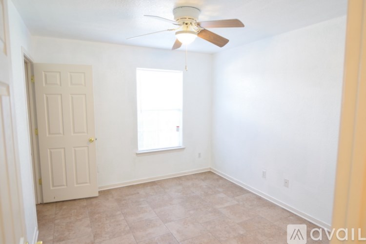 A room with a ceiling fan and a window.