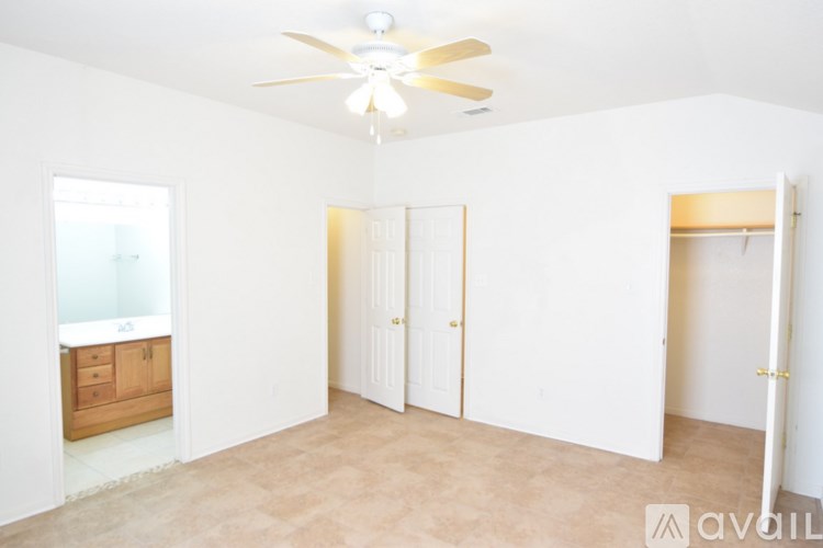 A room with a ceiling fan and a window with a view of a building outside.