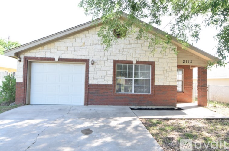 A house with a white garage door and brick walls.