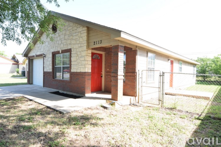 A house with a red door and a brick chimney is for sale.