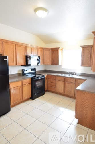 A kitchen with black appliances and wooden cabinets.
