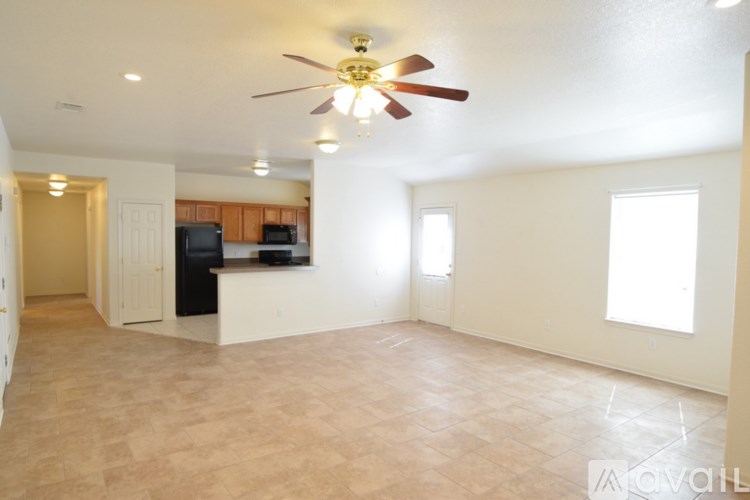 A spacious living room with a ceiling fan and a flat screen TV.