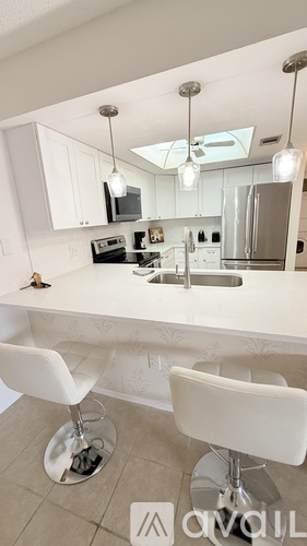 A modern kitchen with white cabinets and stainless steel appliances.