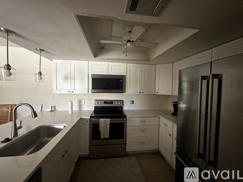 A modern kitchen with white cabinets and stainless steel appliances.