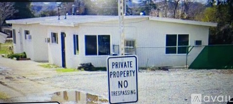 A sign on a pole in front of a building that says Private Property No Trespassing.