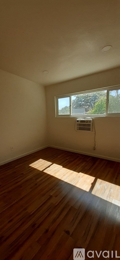 A room with wooden floors and a window.