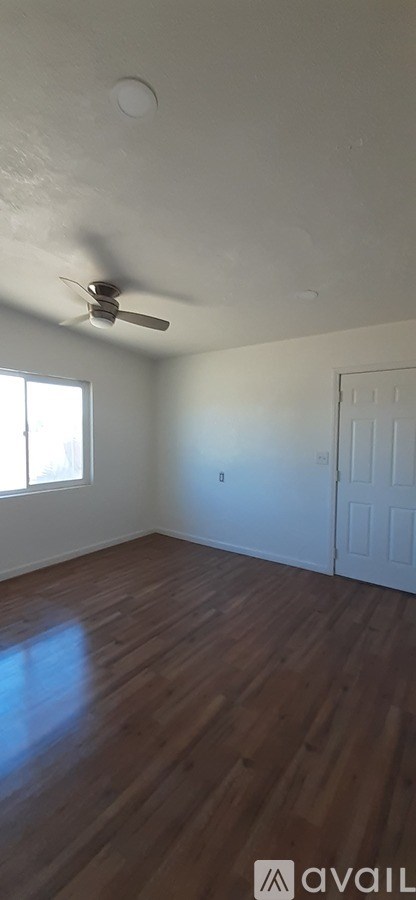 A room with wooden floors and a ceiling fan.