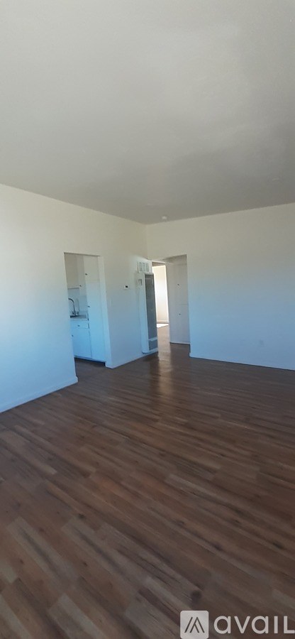 A room with wooden flooring and white walls.
