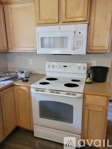 A white stove and microwave above a white oven in a kitchen.