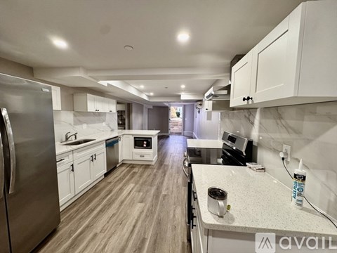 A kitchen with white cabinets and a stainless steel refrigerator.