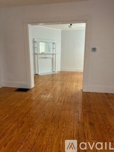 A room with wooden floors and a white door.