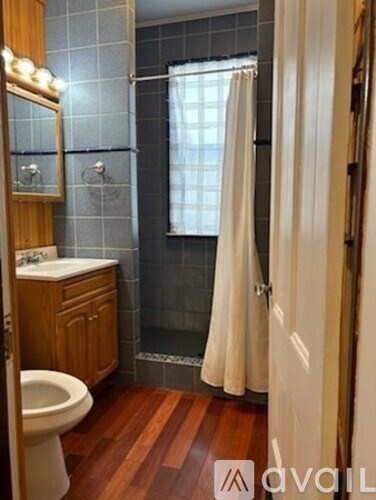 A bathroom with a toilet, sink, and shower.