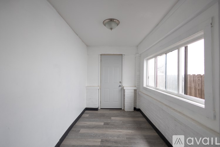 A room with a white door and a window with wooden blinds.