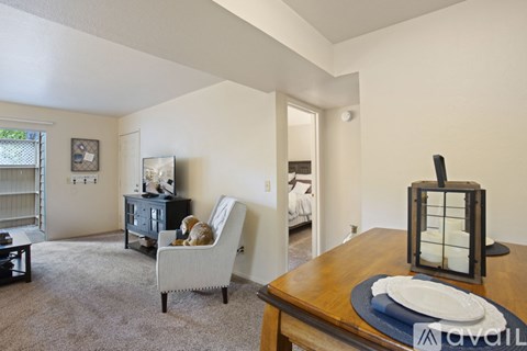 A living room with a brown dining table and a white chair.