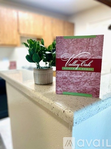 A small potted plant sits on a countertop next to a card for Valley Oak Senior Living.
