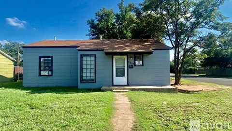 A small house with a white door and a brown roof.