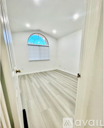 A room with a skylight and a window with blinds.