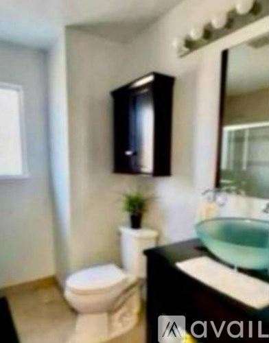 A bathroom with a toilet, sink, and mirror.