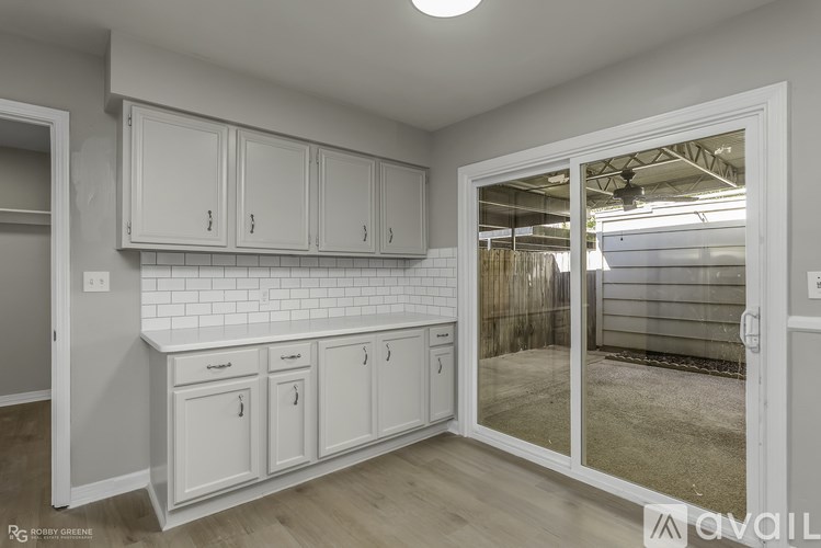 A kitchen with white cabinets and a tiled backsplash.