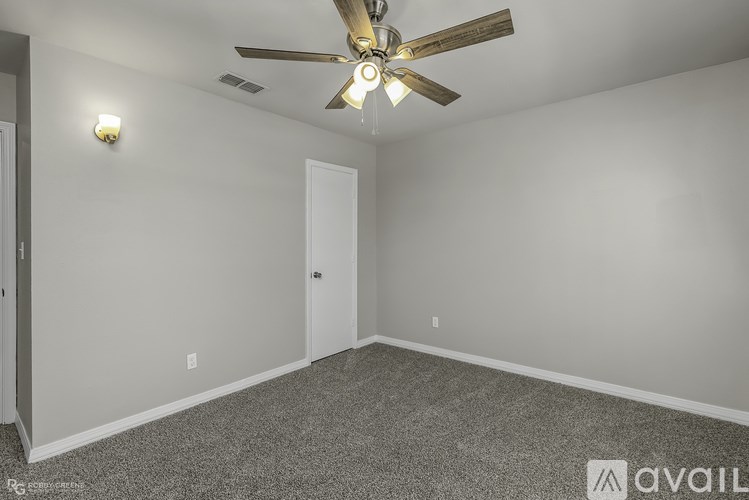 A room with a ceiling fan and carpeted floor.