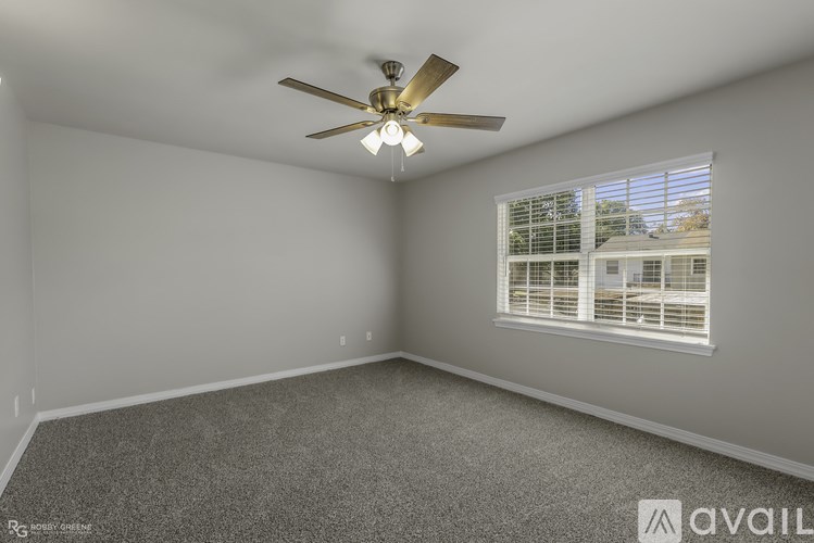 A room with a ceiling fan and a window with blinds.