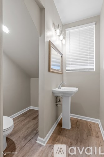 A bathroom with a white sink and toilet.