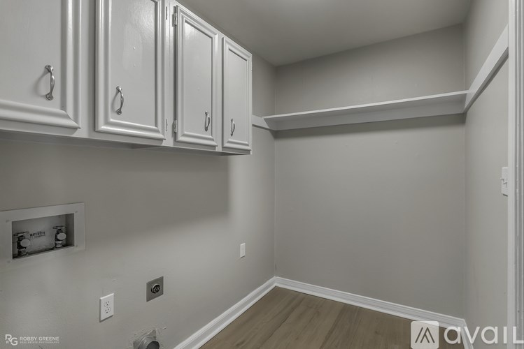 A kitchen with white cabinets and a wooden floor.